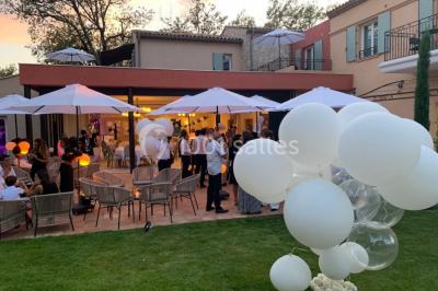 Salle de bain avec baignoire, lavabo moderne sur meuble noir, miroir mural et lumière naturelle par une fenêtre.