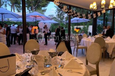 Salle de bain avec baignoire, lavabo moderne sur meuble noir, miroir mural et lumière naturelle par une fenêtre.
