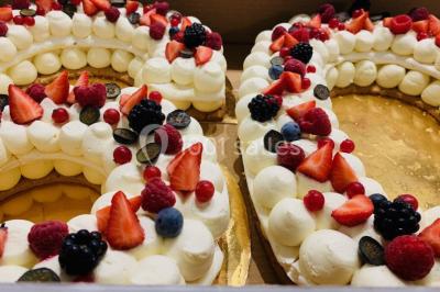 Salle de bain avec baignoire, lavabo moderne sur meuble noir, miroir mural et lumière naturelle par une fenêtre.