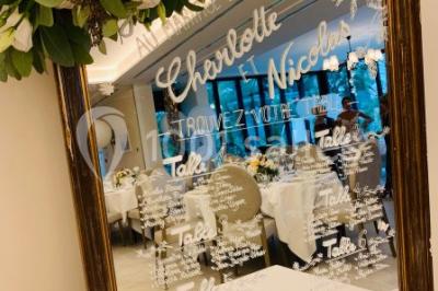 Salle de bain avec baignoire, lavabo moderne sur meuble noir, miroir mural et lumière naturelle par une fenêtre.