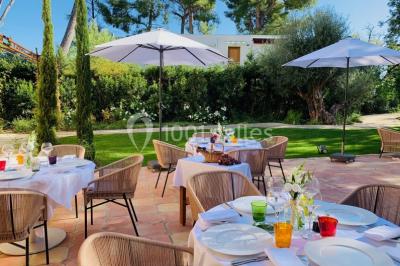 Salle de bain avec baignoire, lavabo moderne sur meuble noir, miroir mural et lumière naturelle par une fenêtre.