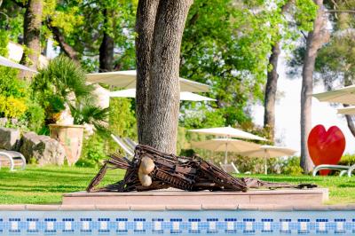 Salle de bain avec baignoire, lavabo moderne sur meuble noir, miroir mural et lumière naturelle par une fenêtre.