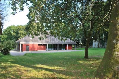 Miniature Location salle Plouay (Morbihan) - Domaine de Manehouarn #3 Cuisine ouverte avec table ronde, chaises, fauteuils, téléviseur, et grande fenêtre laissant entrer la lumière naturelle.