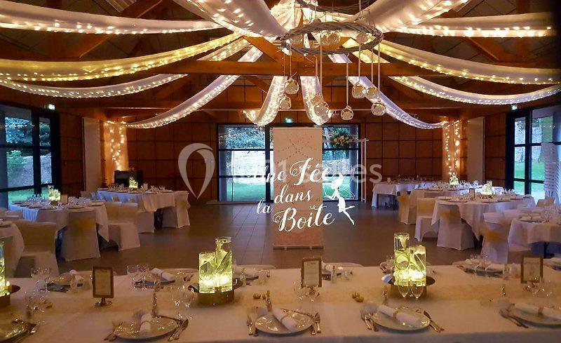 Location salle Plouay (Morbihan) - Domaine de Manehouarn #4 Salle de réception décorée avec des guirlandes lumineuses, des tables dressées et un panneau lumineux central.