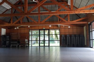 Miniature Location salle Plouay (Morbihan) - Domaine de Manehouarn #12 Cuisine ouverte avec table ronde, chaises, fauteuils, téléviseur, et grande fenêtre laissant entrer la lumière naturelle.