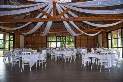 Cuisine ouverte avec table ronde, chaises, fauteuils, téléviseur, et grande fenêtre laissant entrer la lumière naturelle.