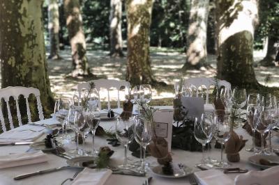 Inscription ’NOUCHET’ gravée sur une façade en pierre et briques, entourée de végétation en arrière-plan.