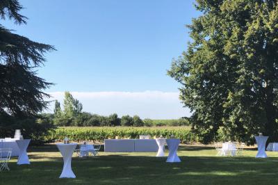 Inscription ’NOUCHET’ gravée sur une façade en pierre et briques, entourée de végétation en arrière-plan.