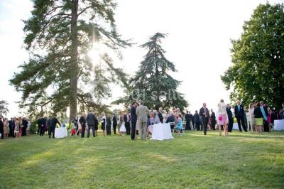 Inscription ’NOUCHET’ gravée sur une façade en pierre et briques, entourée de végétation en arrière-plan.