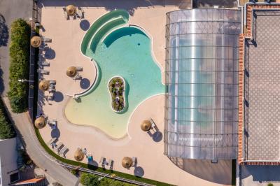 Carafes de jus d'orange et de jus rouge sur une table avec viennoiseries, tasses et verres dans un cadre lumineux.