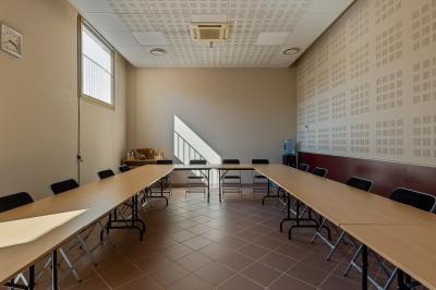Carafes de jus d'orange et de jus rouge sur une table avec viennoiseries, tasses et verres dans un cadre lumineux.