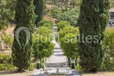 Terrasse en bois aménagée avec des tables, des chaises et des parasols blancs, entourée de végétation.
