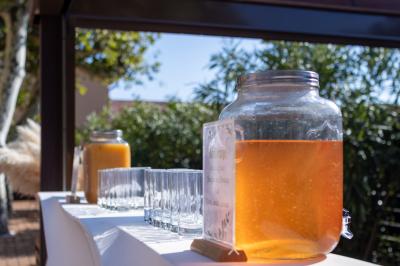 Terrasse en bois aménagée avec des tables, des chaises et des parasols blancs, entourée de végétation.