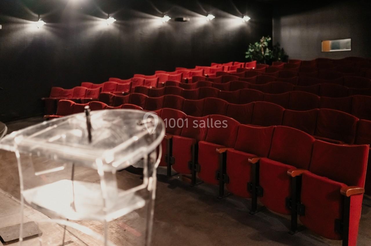 Location salle La Mulatière (Rhône) - Aquarium de Lyon #3 Salle de conférence vide avec des rangées de sièges rouges et un pupitre transparent au premier plan.