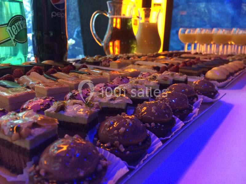 Location salle La Mulatière (Rhône) - Aquarium de Lyon #7 Plateau de desserts variés avec gâteaux, pâtisseries et verrines, disposés sur une table éclairée.