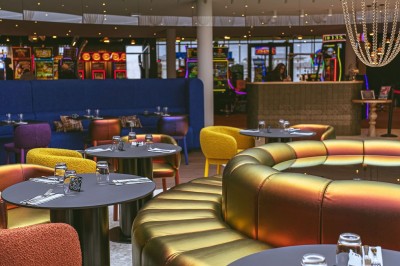 Menu posé sur une table ronde dans un bar élégant avec un comptoir éclairé en arrière-plan.