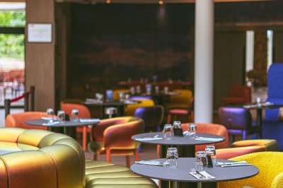 Menu posé sur une table ronde dans un bar élégant avec un comptoir éclairé en arrière-plan.