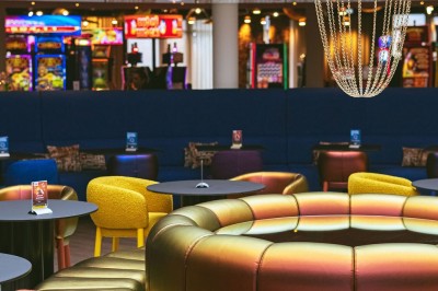 Menu posé sur une table ronde dans un bar élégant avec un comptoir éclairé en arrière-plan.