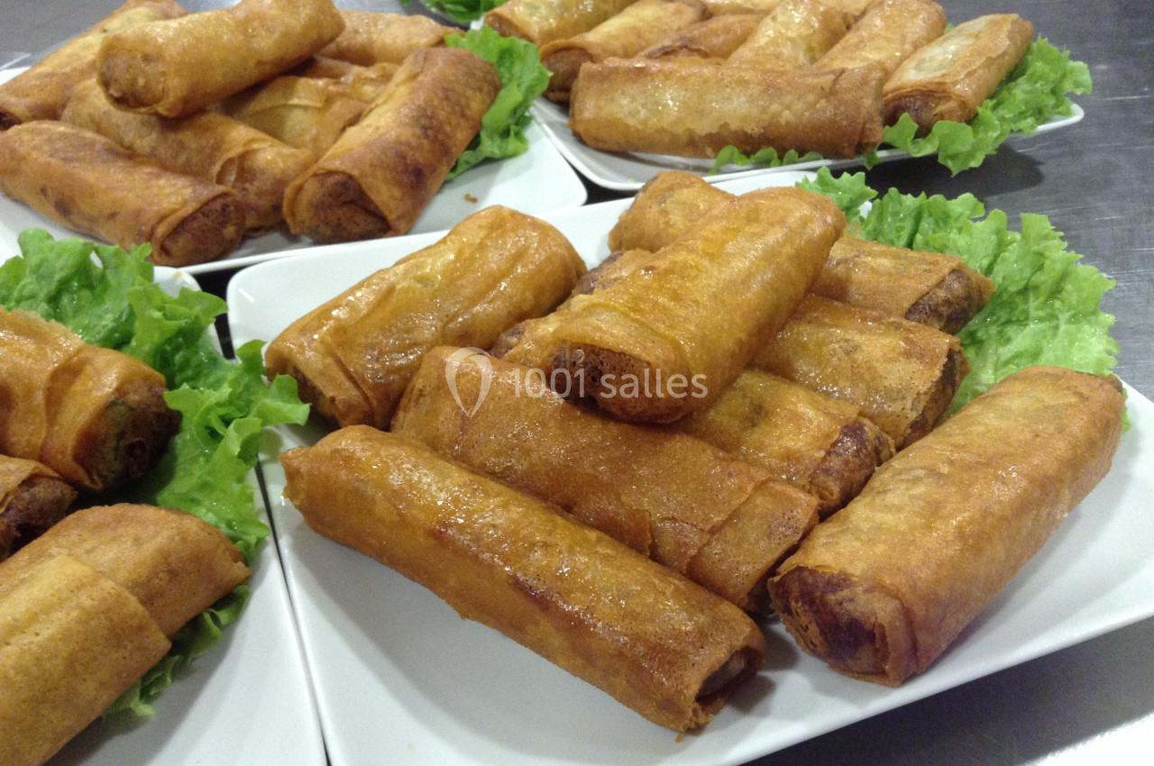 Assiettes remplies de nems dorés disposés sur des feuilles de salade verte.