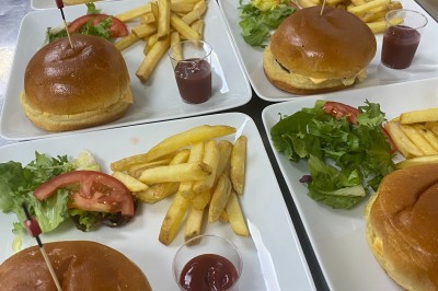 Plateaux garnis de divers amuse-bouches, sandwichs, brochettes et bouchées apéritives disposés sur une table.