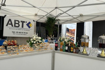 Plateaux garnis de divers amuse-bouches, sandwichs, brochettes et bouchées apéritives disposés sur une table.