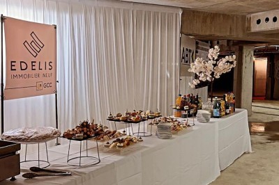 Plateaux garnis de divers amuse-bouches, sandwichs, brochettes et bouchées apéritives disposés sur une table.