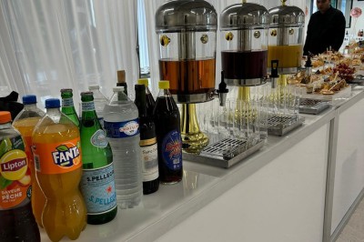 Plateaux garnis de divers amuse-bouches, sandwichs, brochettes et bouchées apéritives disposés sur une table.