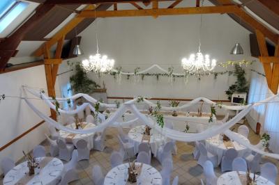Portail en fer forgé rouge avec piliers blancs, donnant sur une allée menant à une maison entourée d'arbres.