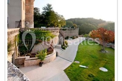 Un concert en plein air au coucher du soleil, avec un public assis devant une scène entourée de verdure.