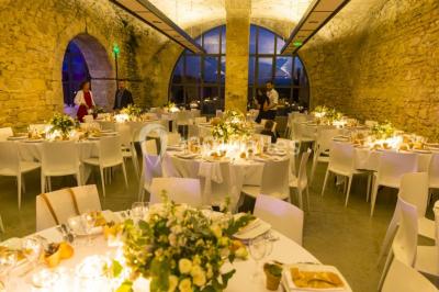 Un concert en plein air au coucher du soleil, avec un public assis devant une scène entourée de verdure.