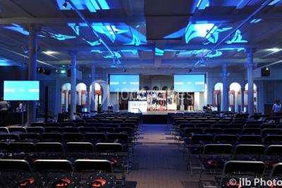 Entrée d'une voie privée bordée de végétation, avec des panneaux d'information et des bâtiments en arrière-plan.