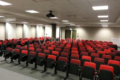 Entrée d'une voie privée bordée de végétation, avec des panneaux d'information et des bâtiments en arrière-plan.