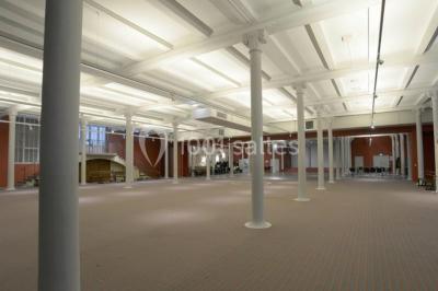 Entrée d'une voie privée bordée de végétation, avec des panneaux d'information et des bâtiments en arrière-plan.