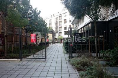 Entrée d'une voie privée bordée de végétation, avec des panneaux d'information et des bâtiments en arrière-plan.