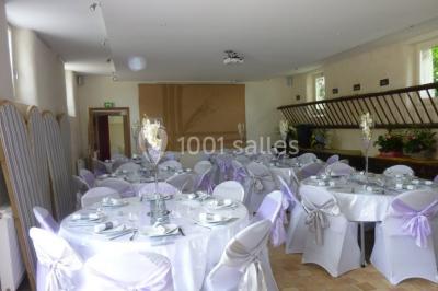 Armoire en bois ouverte contenant des verres, assiettes, bols, carafes et paniers soigneusement rangés sur des étagères.