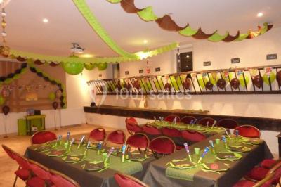 Armoire en bois ouverte contenant des verres, assiettes, bols, carafes et paniers soigneusement rangés sur des étagères.