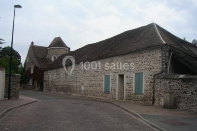 Armoire en bois ouverte contenant des verres, assiettes, bols, carafes et paniers soigneusement rangés sur des étagères.