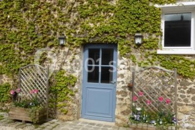 Armoire en bois ouverte contenant des verres, assiettes, bols, carafes et paniers soigneusement rangés sur des étagères.