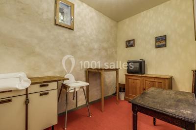 Armoire en bois ouverte contenant des verres, assiettes, bols, carafes et paniers soigneusement rangés sur des étagères.