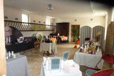 Armoire en bois ouverte contenant des verres, assiettes, bols et carafes, organisée sur plusieurs étagères.