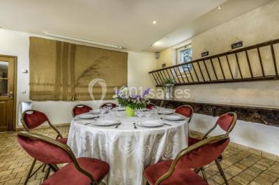 Armoire en bois ouverte contenant des verres, assiettes, bols et carafes, organisée sur plusieurs étagères.