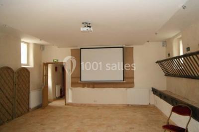 Armoire en bois ouverte contenant des verres, assiettes, bols et carafes, organisée sur plusieurs étagères.