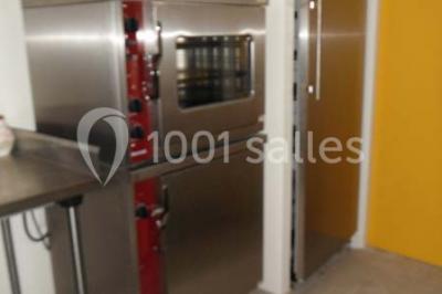 Armoire en bois ouverte contenant des verres, assiettes, bols et carafes, organisée sur plusieurs étagères.