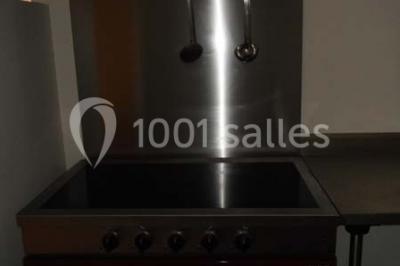 Armoire en bois ouverte contenant des verres, assiettes, bols et carafes, organisée sur plusieurs étagères.