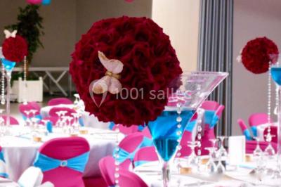 Salle de réception avec bar éclairé par des lumières colorées et invités rassemblés dans une ambiance tamisée.