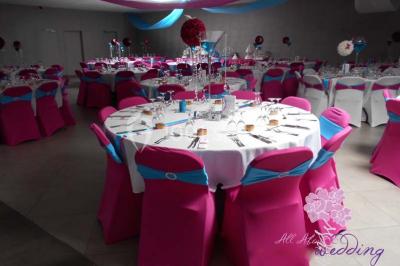 Salle de réception avec bar éclairé par des lumières colorées et invités rassemblés dans une ambiance tamisée.