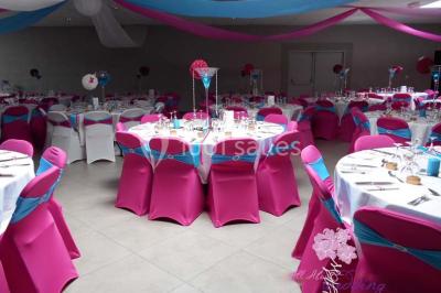 Salle de réception avec bar éclairé par des lumières colorées et invités rassemblés dans une ambiance tamisée.