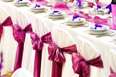 Salle de réception avec bar éclairé par des lumières colorées et invités rassemblés dans une ambiance tamisée.