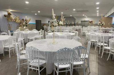 Salle de réception avec bar éclairé par des lumières colorées et invités rassemblés dans une ambiance tamisée.