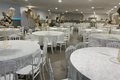 Salle de réception avec bar éclairé par des lumières colorées et invités rassemblés dans une ambiance tamisée.